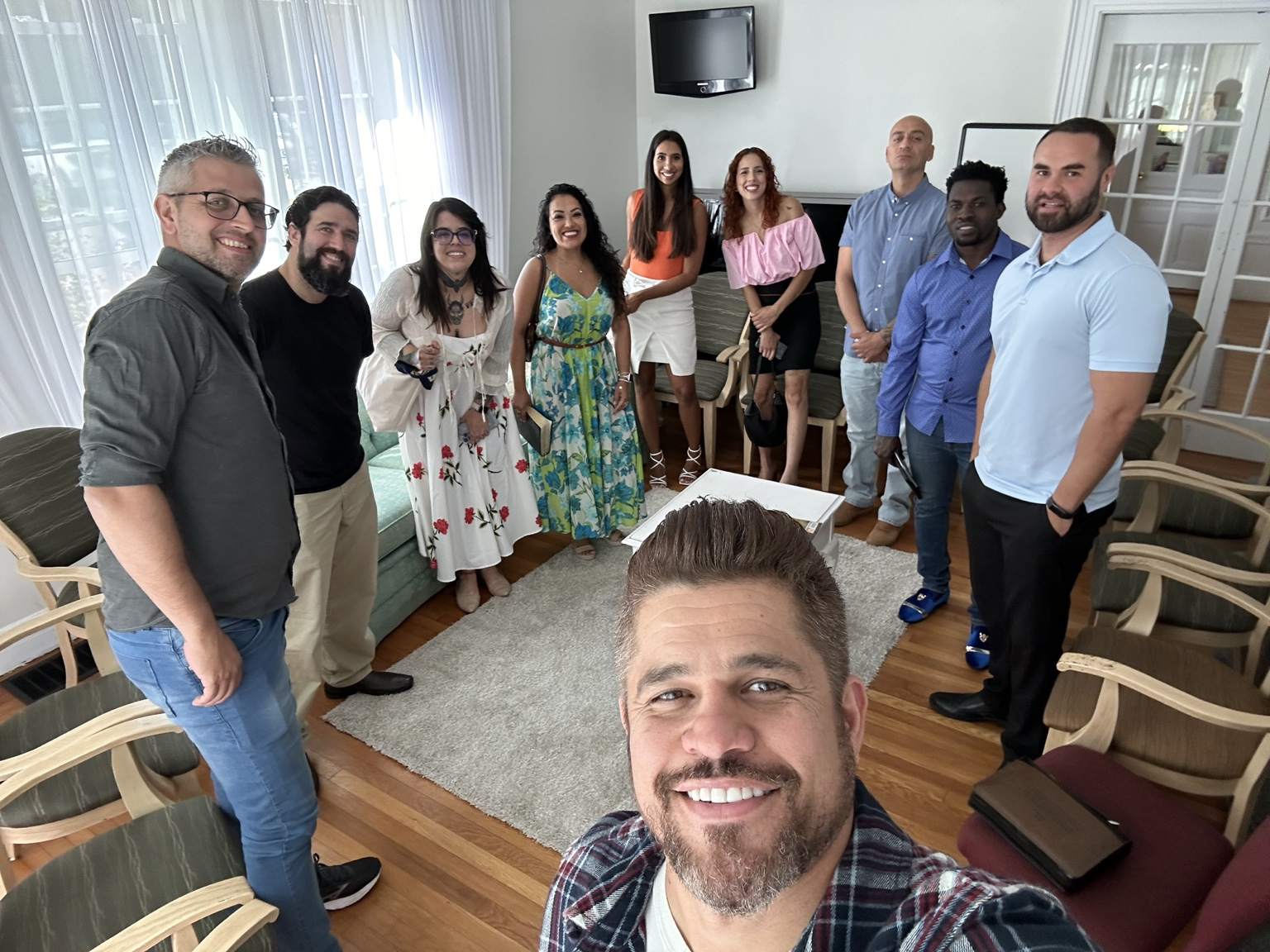 Romulo taking a group photo with friends gathered together in a living room